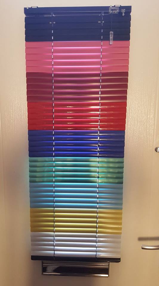 metal Venetian blinds styled in layers of different colours 